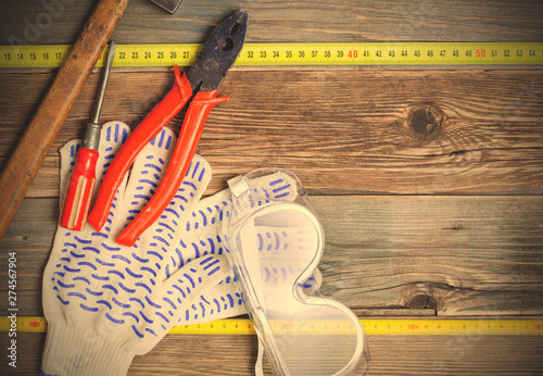 vintage hammer, pliers, screwdriver, tape measure, gloves and safety glasses