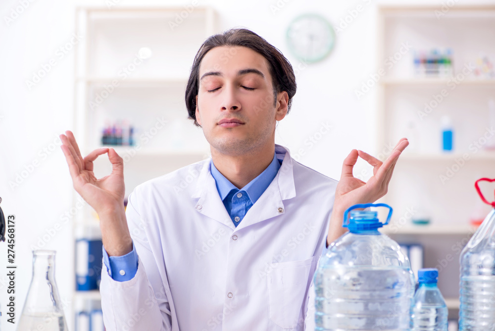 Young male chemist experimenting in lab Young male chemist experimenting in lab