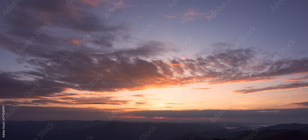 Panoramic view of colorful clouds at the sunrise in mountains