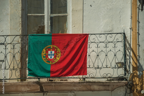 Portuguese flag on top of iron handrail of balcony