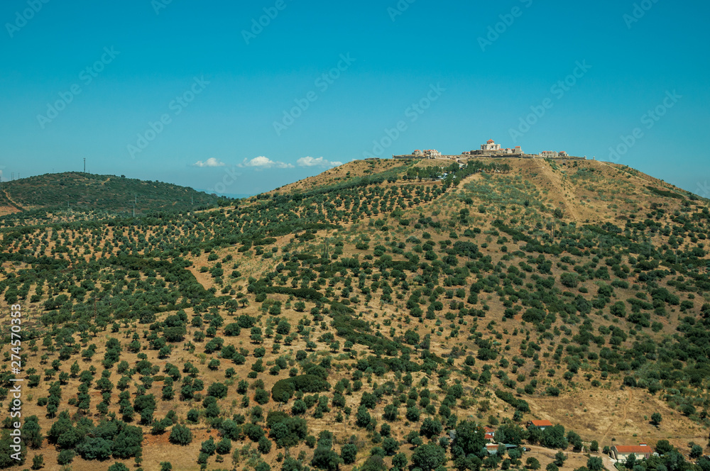 Landscape with fortress of on top of hill and small farms