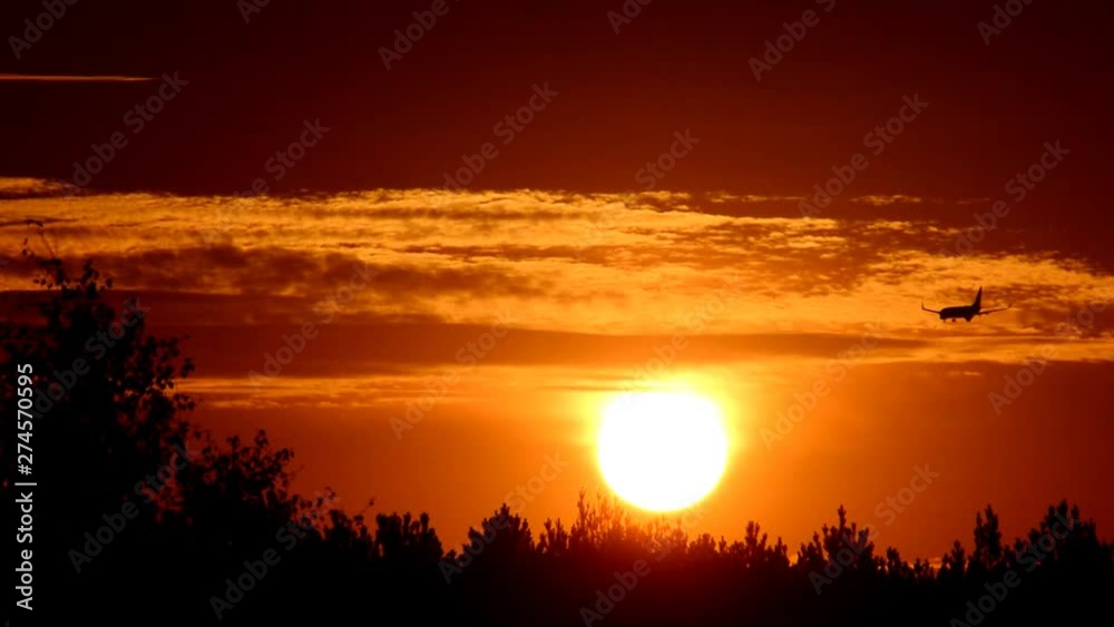 Silhouette of airplane in front of the rising sun at the landing approach on Tegel Airport over Berlin Spandau on October 11, 2015, Germany Silhouette of airplane in front of the rising sun at the landing approach on Tegel Airport over Berlin Spandau on October 11, 2015, Germany