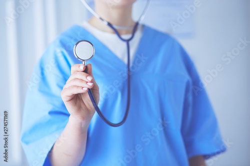 Young and confident male doctor with stethoscope in his hands. Successful doctor career concept