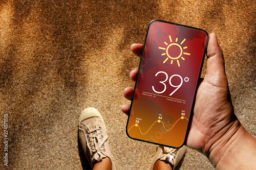 Ecology and Technology Concept. High Temperature Weather show on Mobile Screen on Hot Sunny Day. Top View, Grunge Dirty Concrete Floor with Sunlight as background photo