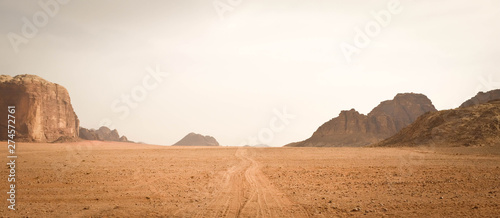 Sand pathway through Wadi Rum desert, Jordan. Mountain range in the background.