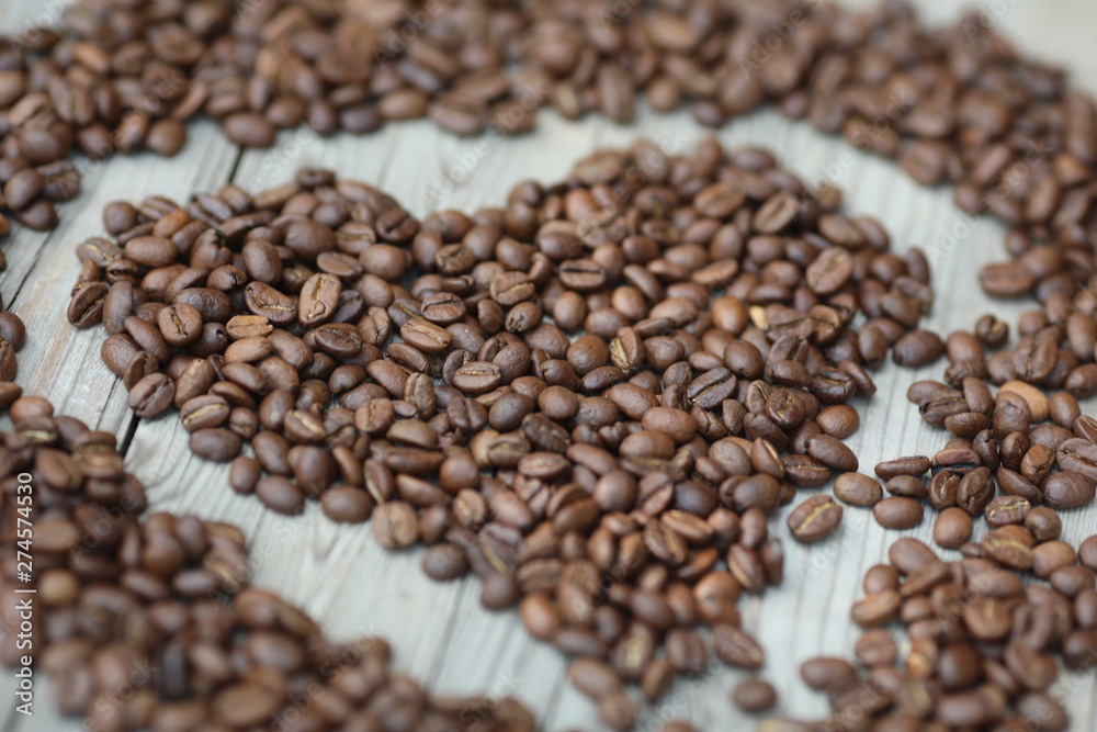 Coffe beans in hands and on the wooden table, roasted arabica Coffe beans in hands and on the wooden table, roasted arabica