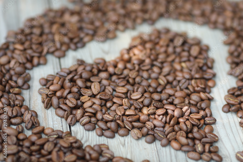 Coffe beans in hands and on the wooden table, roasted arabica Coffe beans in hands and on the wooden table, roasted arabica