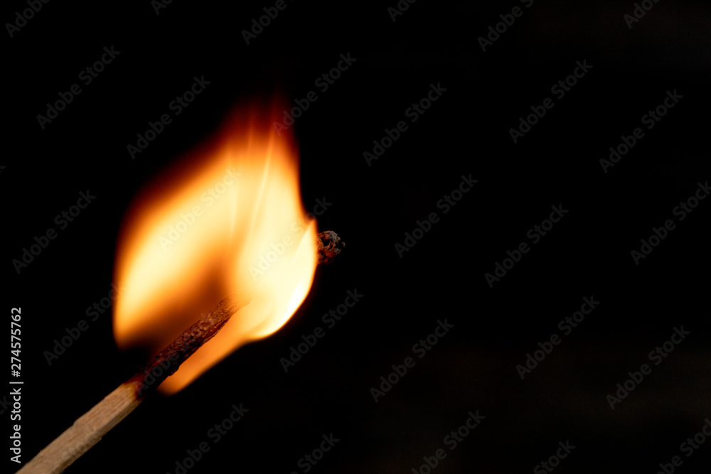 burning match with red, orange ,yello fire isolated on black background