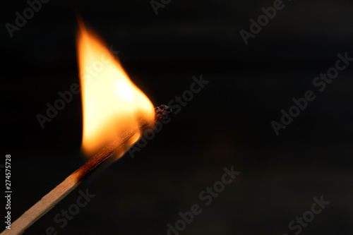 burning match with red, orange ,yello fire isolated on black background