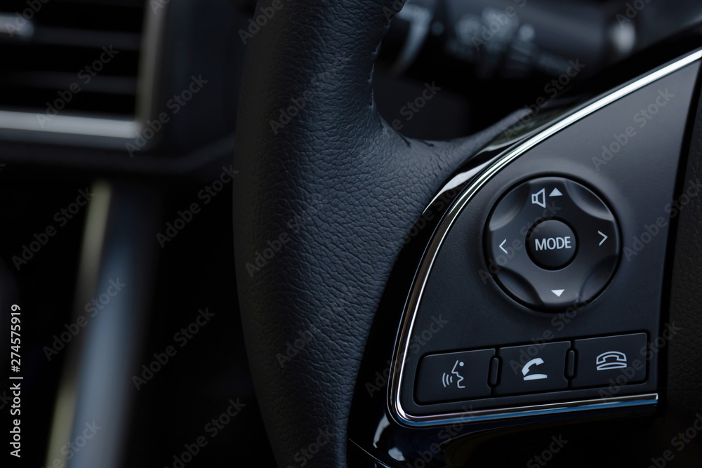 close up Modern black steering wheel with multifunction buttons Integrated stereo controls pushes the for quick control technology in the car. 