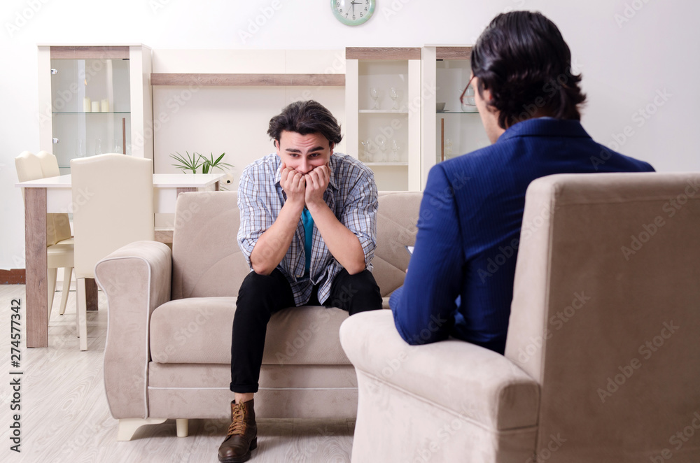 Young male patient discussing with psychologist personal problem Young male patient discussing with psychologist personal problem