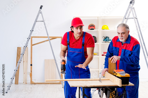 Two professional contractors laying flooring at home 