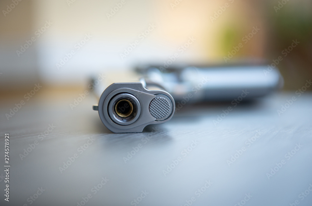 Close up of gun barrel on the wooden table