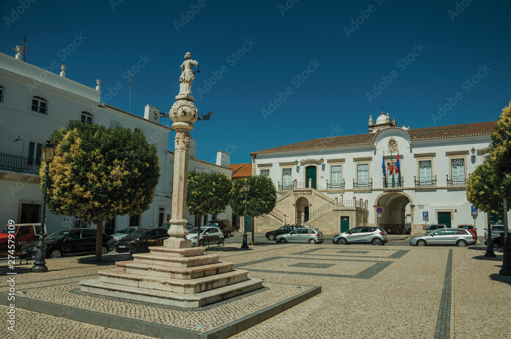 Obraz premium Marble pillory with sculpture in square and City Hall in the back