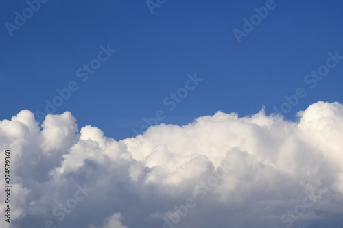 Blue sky with clouds background. Sky with cumulus clouds. Big air clouds in the blue sky. Selective focus. Copy space.