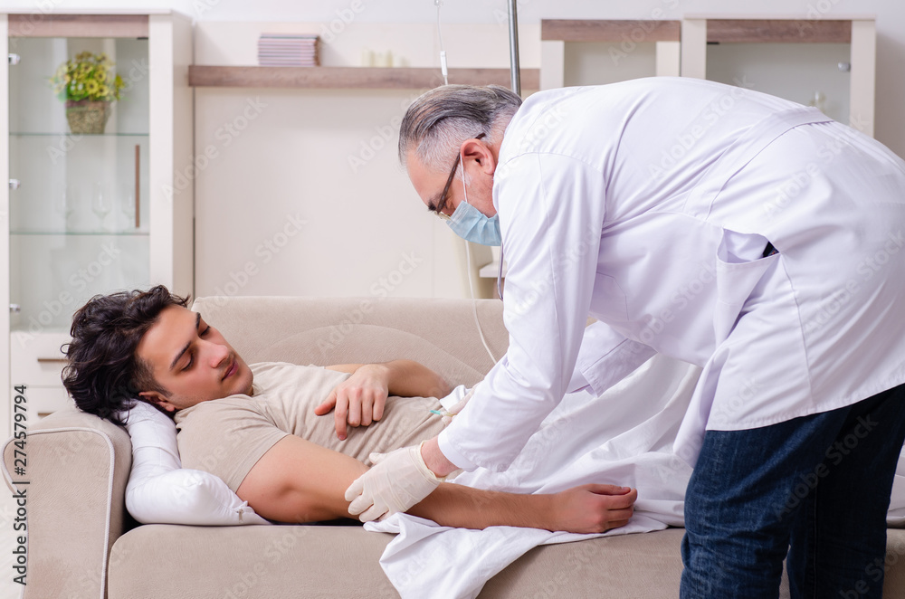 Fototapeta premium Old male doctor visiting young male patient 