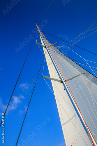 Main sail of a sailing yacht against a blue sky