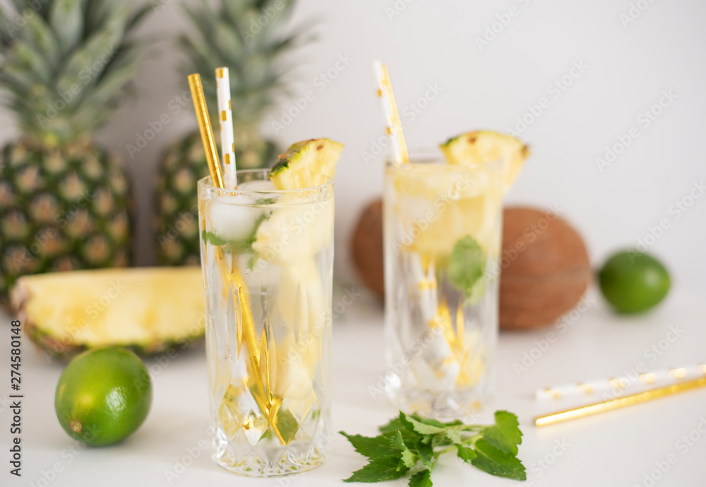 Fototapeta premium Cold pineapple cocktail with crushed ice, lime, coconut and mint, tropical refreshing lemonade drink