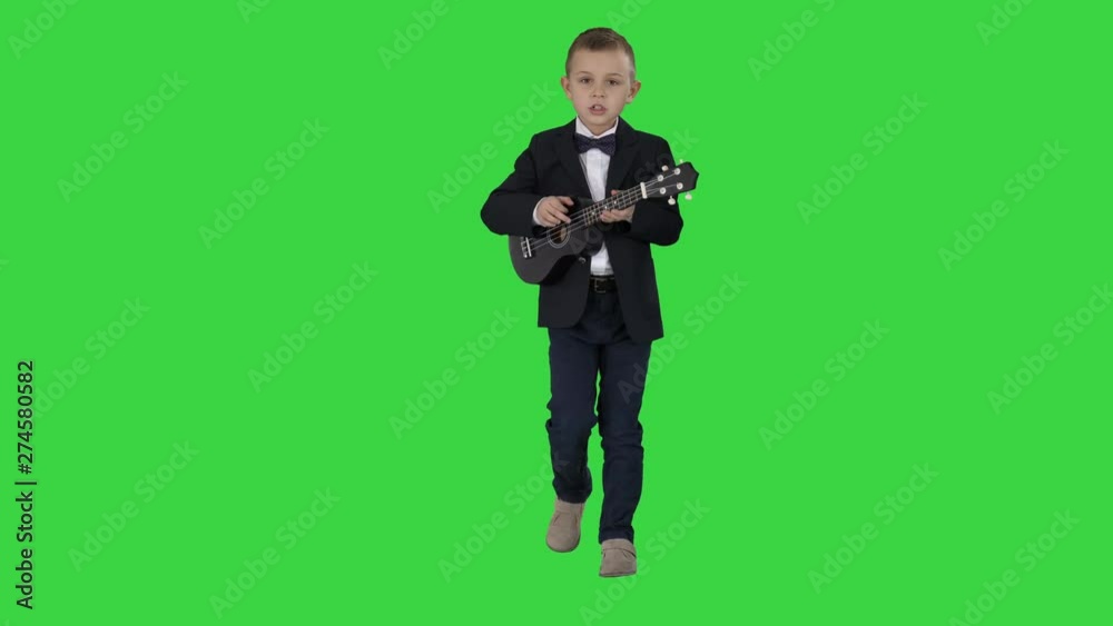 Boy in a costume walking and playing ukulele on a Green Screen, Chroma