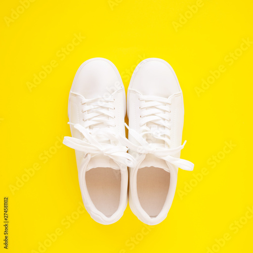 Perfect white New sneakers standing on a bright yellow background.