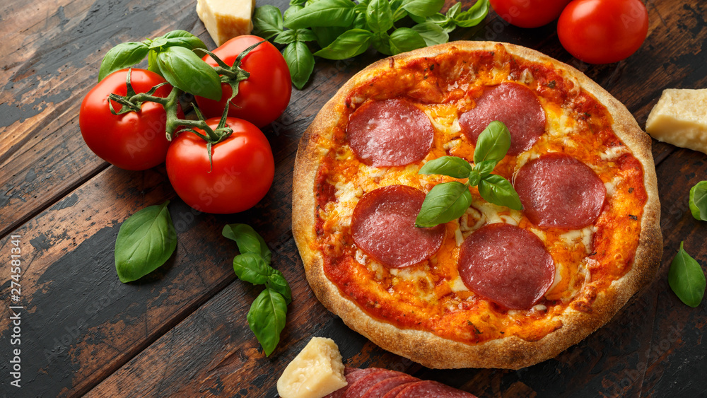 Homemade Pepperoni, Salami Pizza with basil, tomatoes, cheese on wooden table. ready to eat Homemade Pepperoni, Salami Pizza with basil, tomatoes, cheese on wooden table. ready to eat