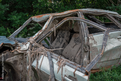 the body of a crashed car drowned in mud stands on the grass