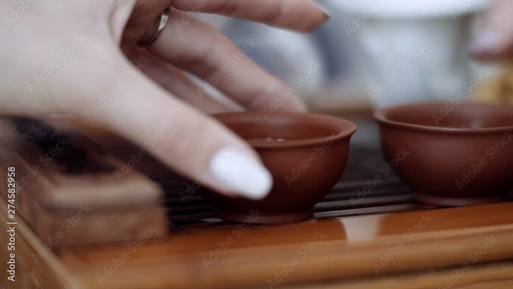 Close-up, the hands of the girls take gently on a small Cup of fragrant tea Close-up, the hands of the girls take gently on a small Cup of fragrant tea