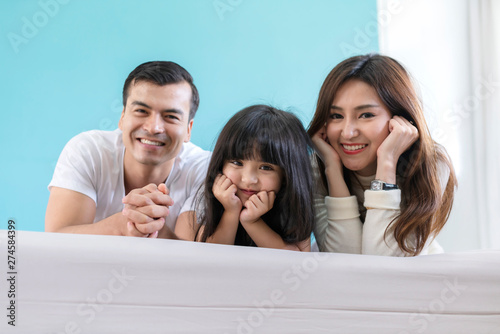 happy Asian Family mother father and daughter making a fun sleep play in living room home background.