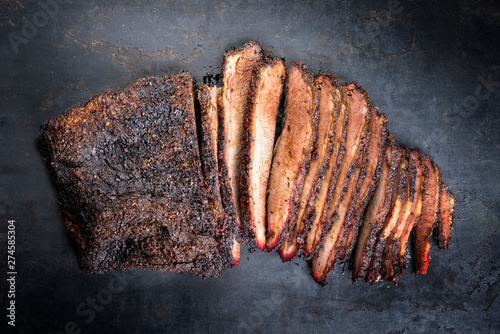 Traditional smoked barbecue wagyu beef brisket offered as top view on an old rustic board with copy space  photo