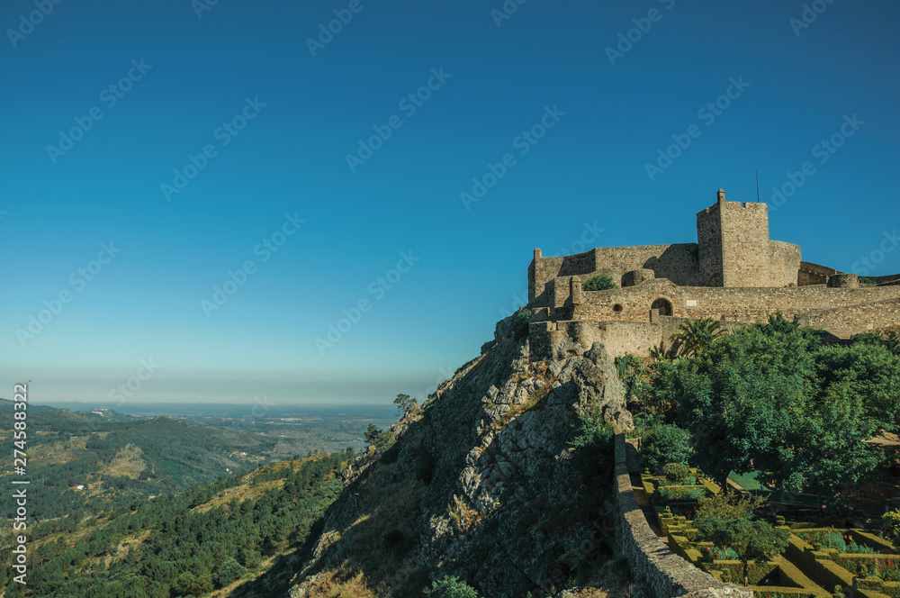 Stone walls and tower of Castle over rocky cliff at Marvao