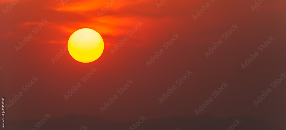 Glowing summer sun setting over mountain range. Glowing summer sun setting over mountain range.