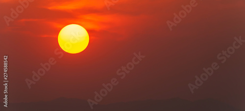 Glowing summer sun setting over mountain range. © Tanes
