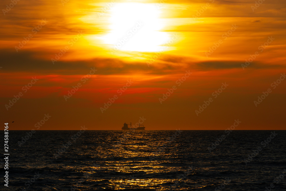 Red sunset with ship in center