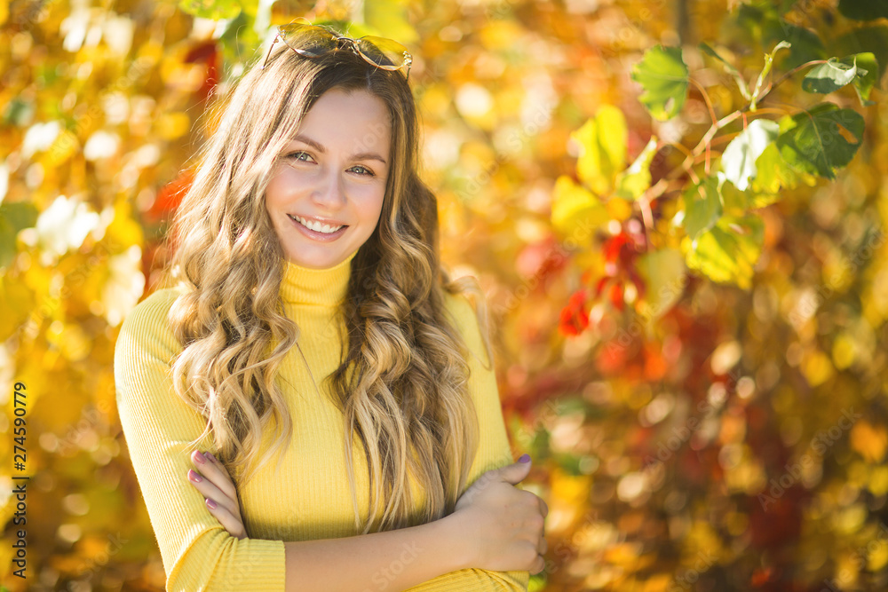 Young attractive blond woman outdoors on fall background. Autumn portrait of beautiful stylish woman. Young attractive blond woman outdoors on fall background. Autumn portrait of beautiful stylish woman.