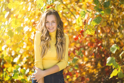 Young attractive blond woman outdoors on fall background. Autumn portrait of beautiful stylish woman.