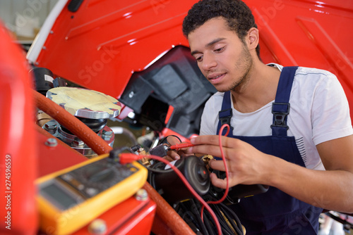 mechanic working on electrical system in the engine