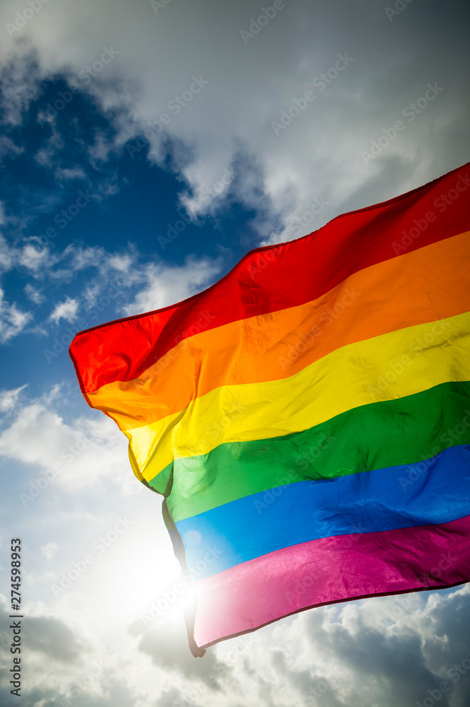 Obraz premium Close-up of gay pride rainbow flag fluttering backlit in bright sunny sky
