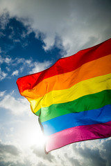 Close-up of gay pride rainbow flag fluttering backlit in bright sunny sky
