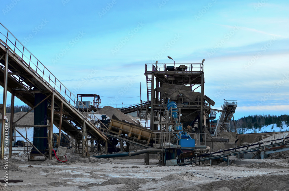 Sand mining in winter conditions in an industrial quarry. Conveyor Belt in mining quarry, Mining industry. Amazing mountains against the backdrop of snow and industry