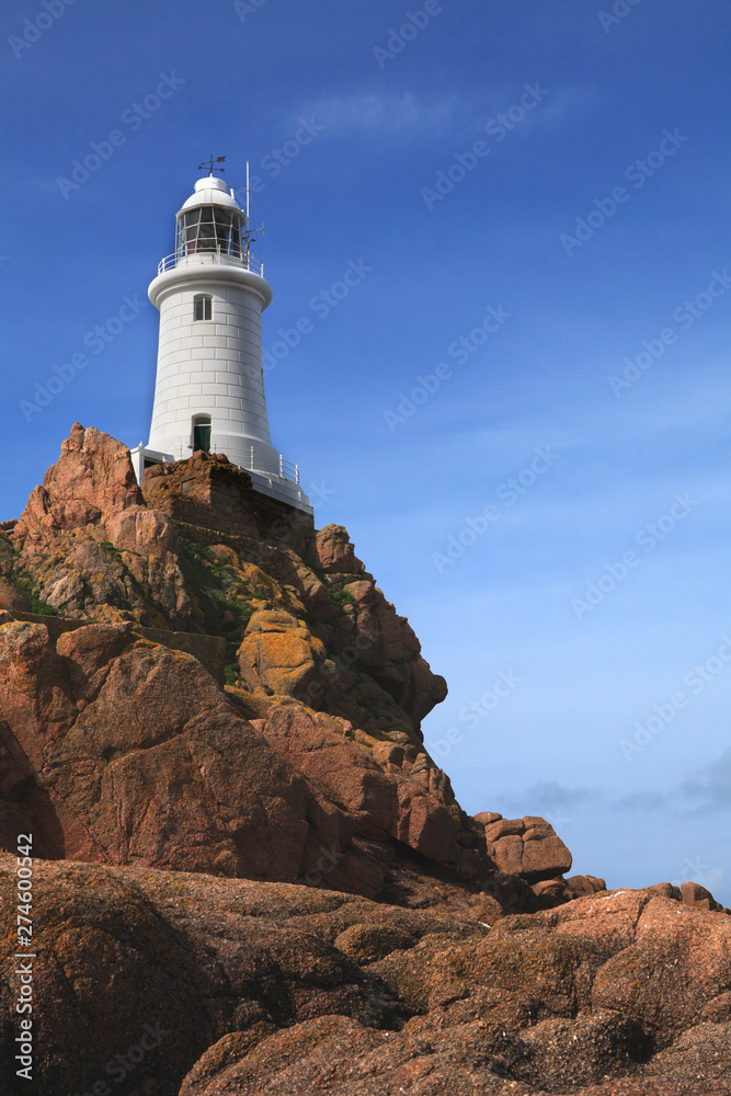 old 19th century english lighthouse on top of a craggy rock