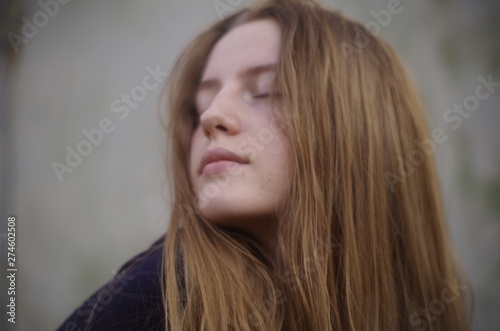 beautiful young blonde with long flowing hair on a blurry background