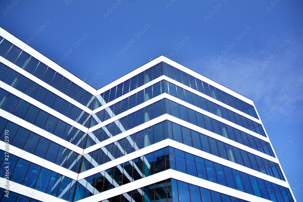 New office building in business center. Wall made of steel and glass with blue sky. New office building in business center. Wall made of steel and glass with blue sky.