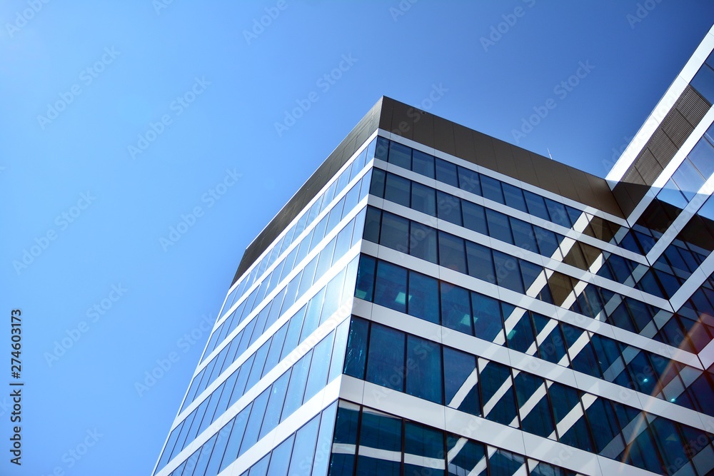 New office building in business center. Wall made of steel and glass with blue sky. New office building in business center. Wall made of steel and glass with blue sky.