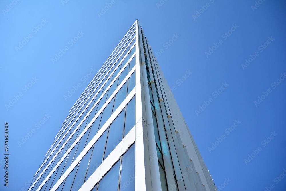 New office building in business center. Wall made of steel and glass with blue sky. New office building in business center. Wall made of steel and glass with blue sky.