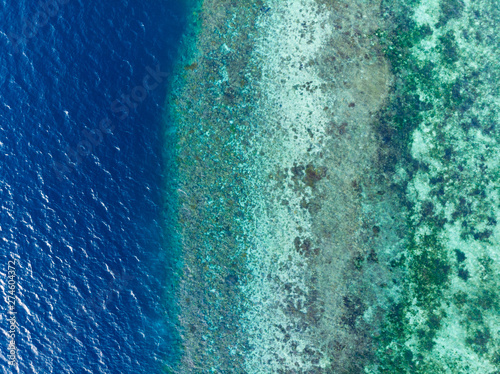 Aerial top down coral reef tropical caribbean sea, turquoise blue water. Indonesia Wakatobi archipelago, marine national park, tourist diving boat travel destination