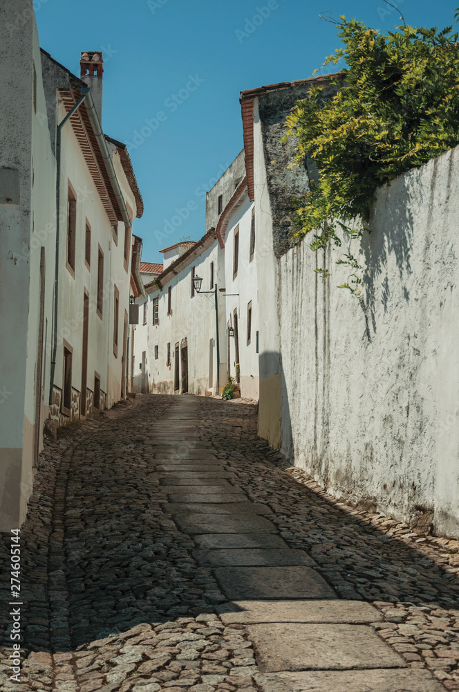 Old house and worn plaster walls in cobblestone alley