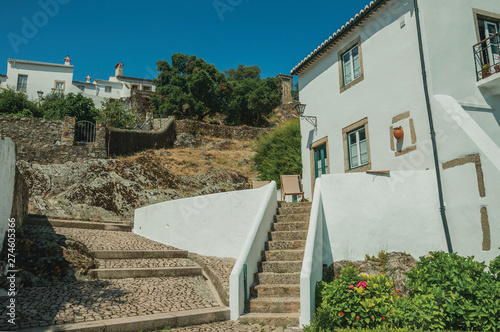 Old whitewashed wall house with stairs and green garden