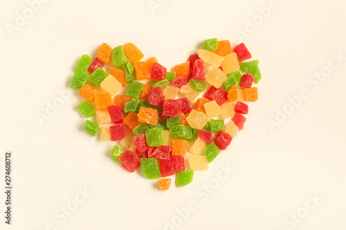 Heap of colorful delicious candied fruits in shape of heart photo