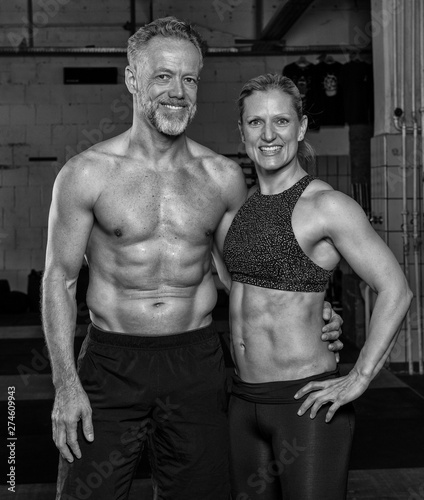 Sportliches Paar mittleren Alters hat zusammen Spaß beim Sport. Die sportliche blonde Frau in den Vierzigern und der athletische Mann in den Fünfzigern beim Krafttraining. Arm in Arm. photo