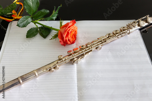 Cross flute silver-plated on empty musical score